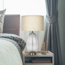 Ribbed glass table lamp illuminating a contemporary bedroom nightstand