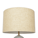 Close-up detail of the textured ribbed glass body meeting the polished gold metal base
