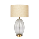 Aurora ribbed glass lamp casting warm, ambient light over a cozy reading nook