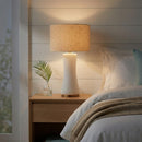 Front view of the Cascade off-white glass table lamp on a sophisticated living room side table