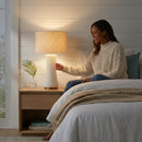 Elegant off-white glass table lamp illuminating a luxury bedroom nightstand