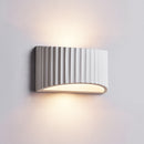 Soft, indirect warm light washing gracefully upward and downward across a bedroom wall