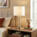 Front view of the Luna 28-inch clear glass table lamp in a brightly lit modern living room