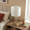 Elegant clear glass table lamp illuminating a contemporary bedside nightstand