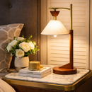 Elegant solid wood desk lamp illuminating a modern mid-century wooden writing desk