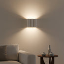 Front view of the mid-century modern fabric wave LED wall sconce mounted above a cozy bedroom headboard