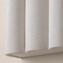 Elegant wave-shaped fabric wall sconce illuminating a contemporary hotel suite accent wall