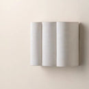 Angled perspective showcasing the sleek, low-profile geometric wave design of the wall lamp