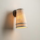 Close-up detail of the organic textured linen fabric shade and dark forged iron arm