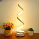 Close-up detail of the modern white spiral LED lamp casting a soft, warm glow