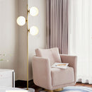 Modern minimalist gold floor lamp illuminating a contemporary living room seating area