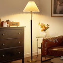Front view of a modern pleated fabric floor lamp illuminating a contemporary living room