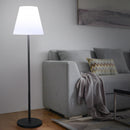 Tall Nordic minimalist floor lamp standing next to a contemporary fabric sofa
