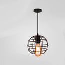 Vintage wrought iron cage pendant light illuminated above a moody wooden bar counter