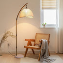 Tall vertical retro floor lamp positioned gracefully beside a textured plaster wall